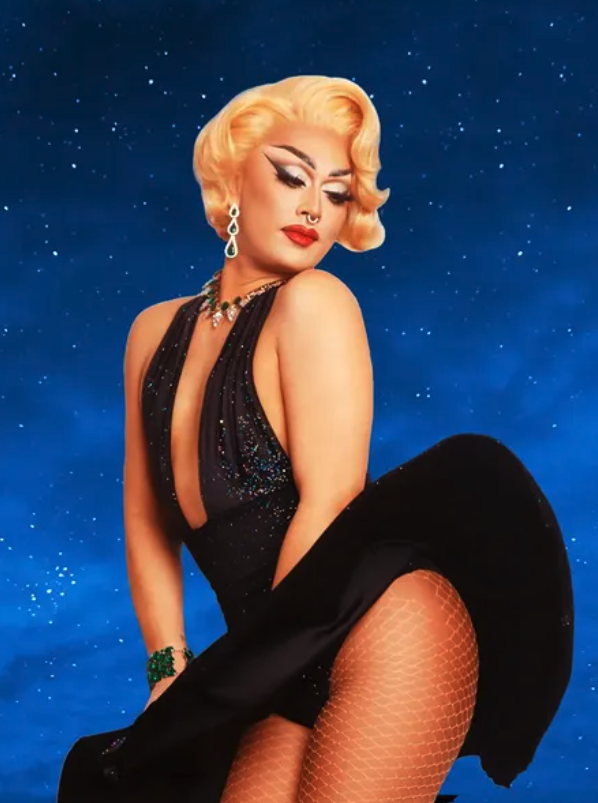 Ivy Leaguee with blonde vintage waves, wearing a black sparkling dress and green jewellery