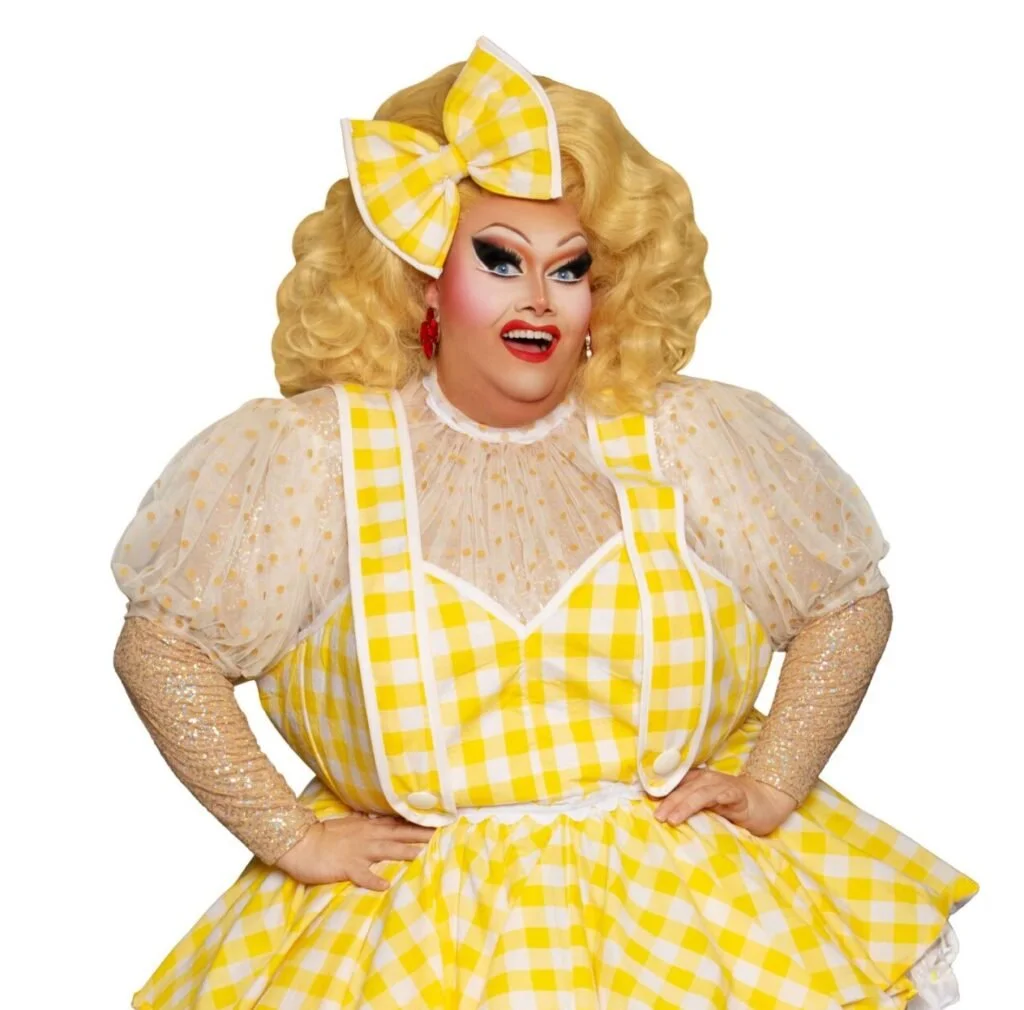 Felicity Frockaccino in a yellow gingham outfit with blonde curls and a matching oversized bow