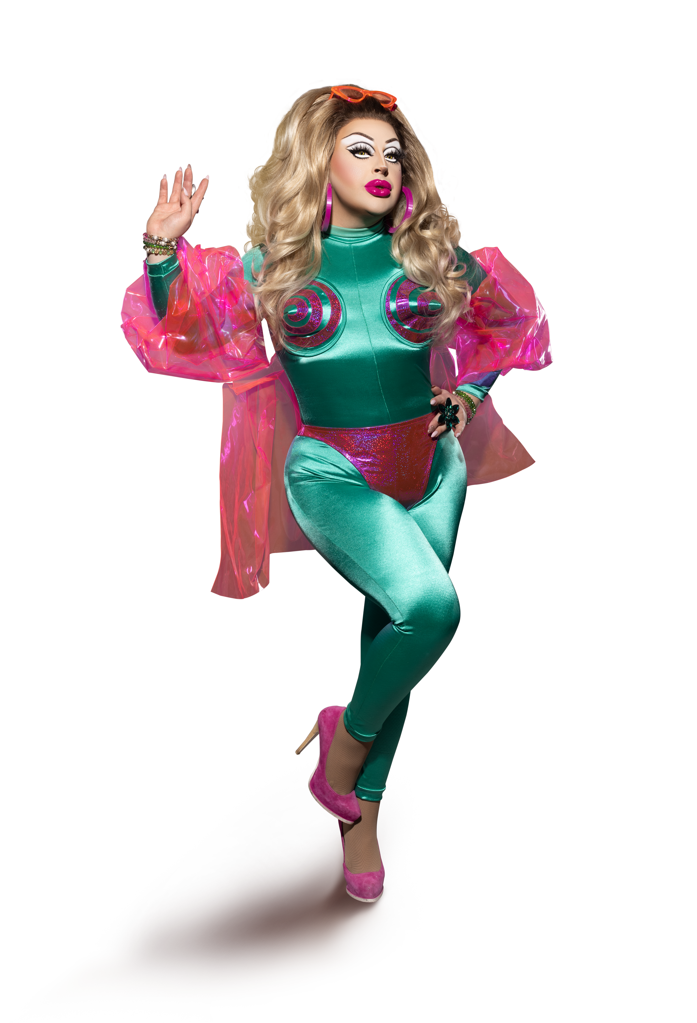 Hannah Conda with blonde curls, orange sunglasses and a turquoise costume with bright pink sleeves