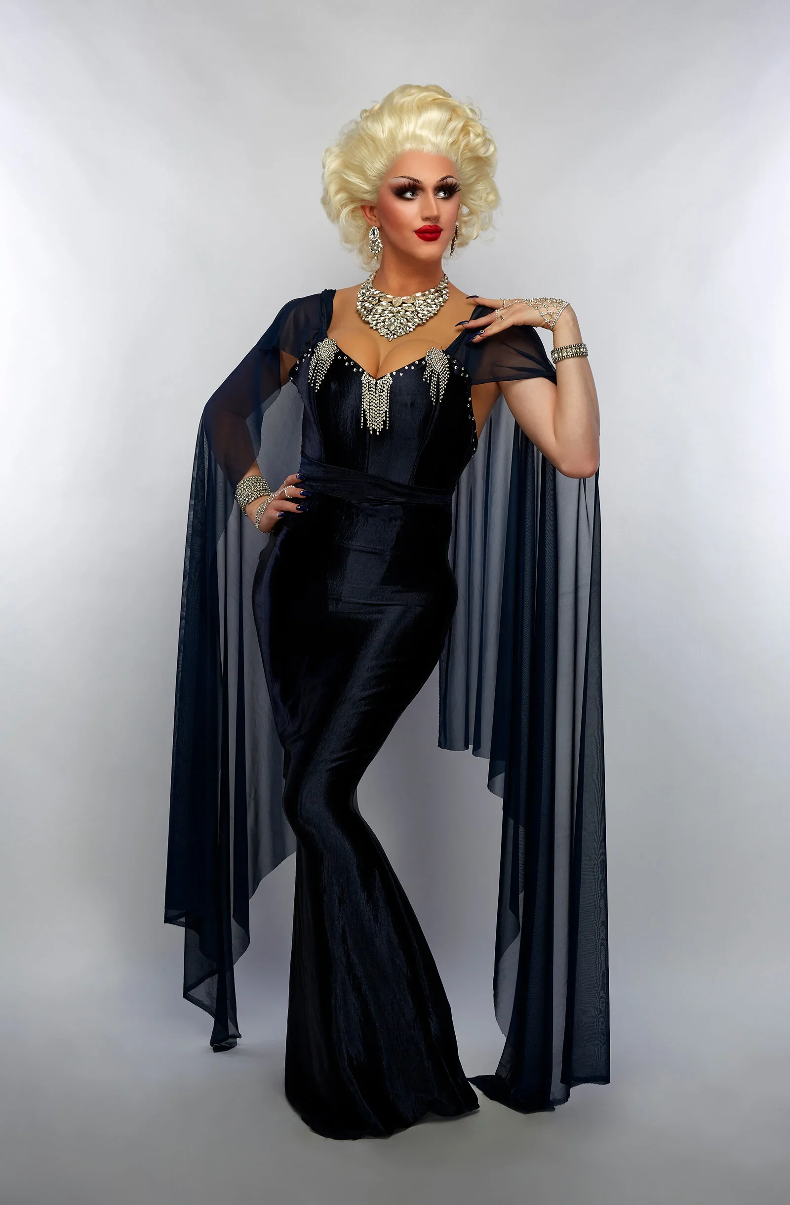Mynx Moscato with blonde curls, sparkling jewellery and a black gown