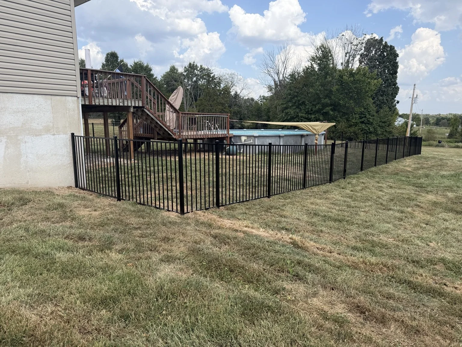 Two-rail aluminum fence installed for a Marine veteran on a rural Wentzville-area property