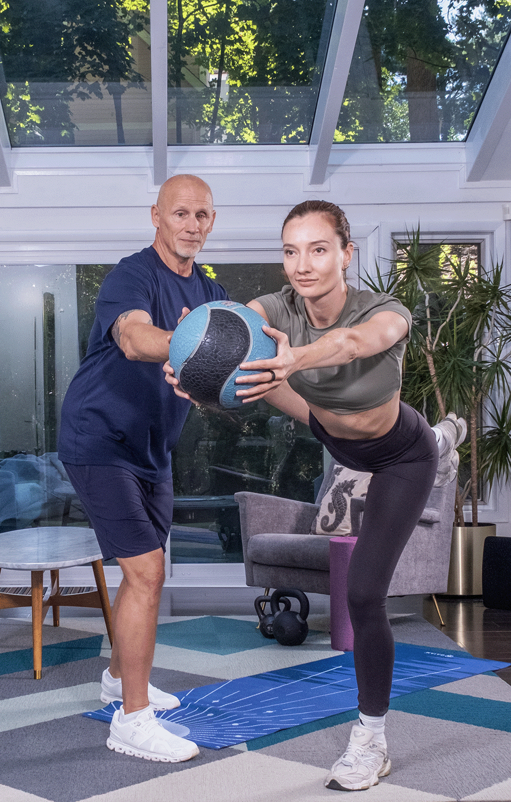 Adult performing a balance and stability exercise with a trainer