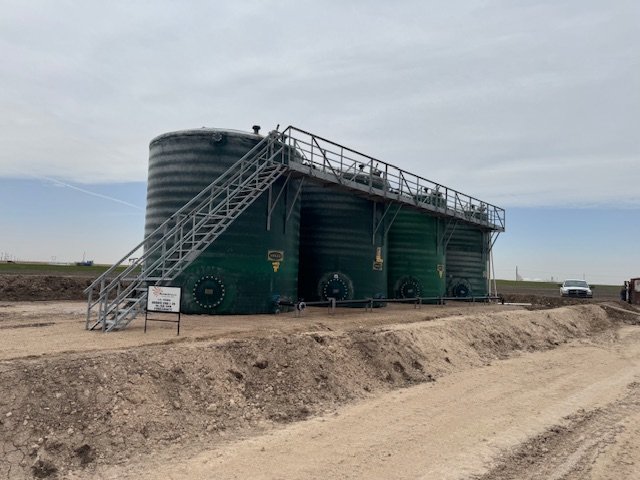 Row of green storage tanks with a catwalk