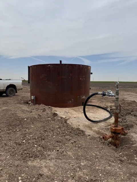 Round steel tank on a dirt pad