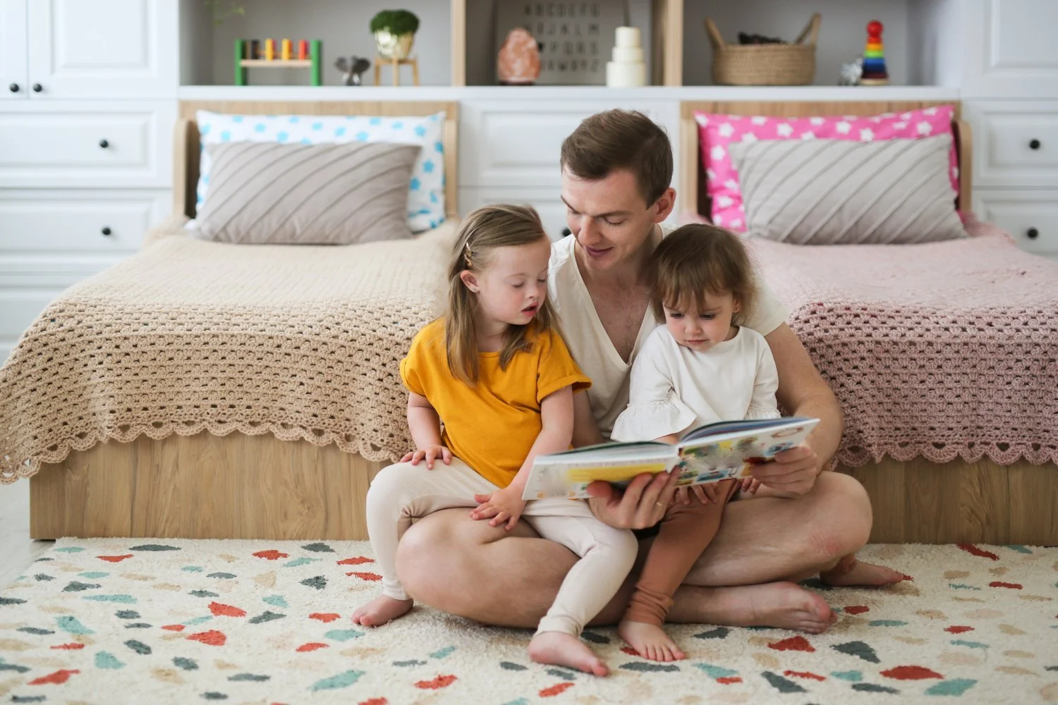 A father reading a bedtime story with his daughters