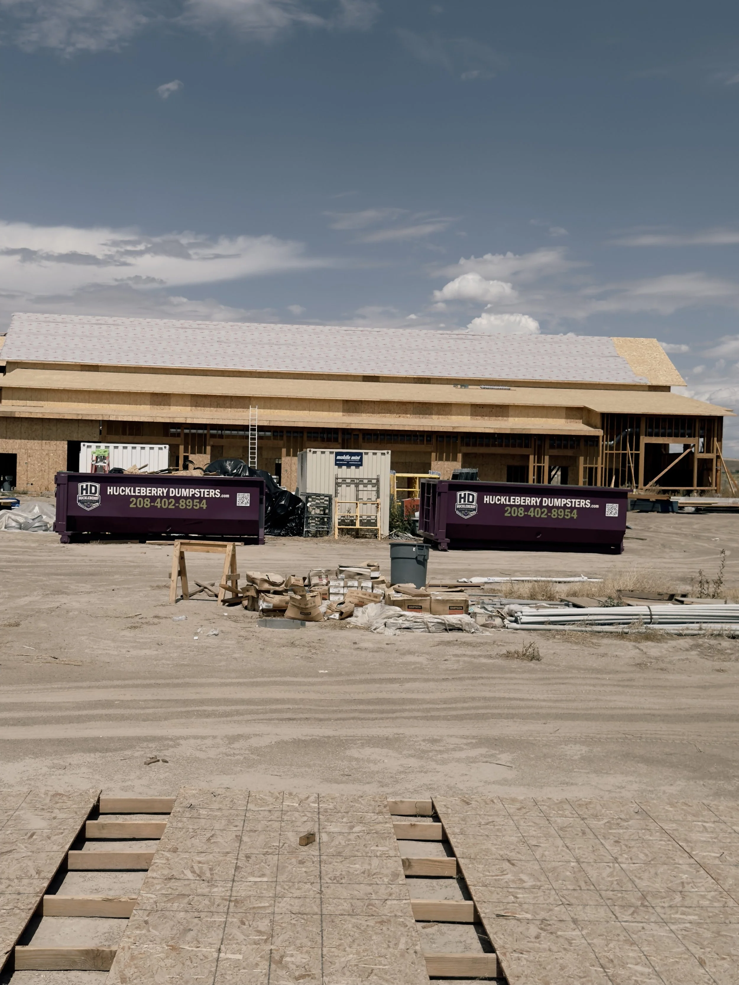 Two purple Huckleberry Dumpsters serving an active Treasure Valley construction project