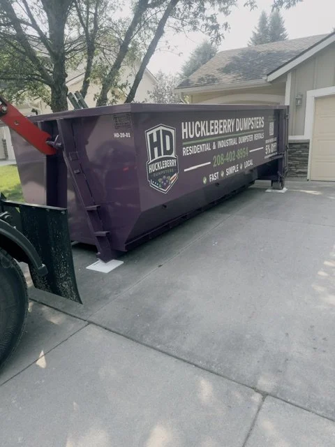 Huckleberry Dumpsters 20-yard purple dumpster placed in a residential driveway
