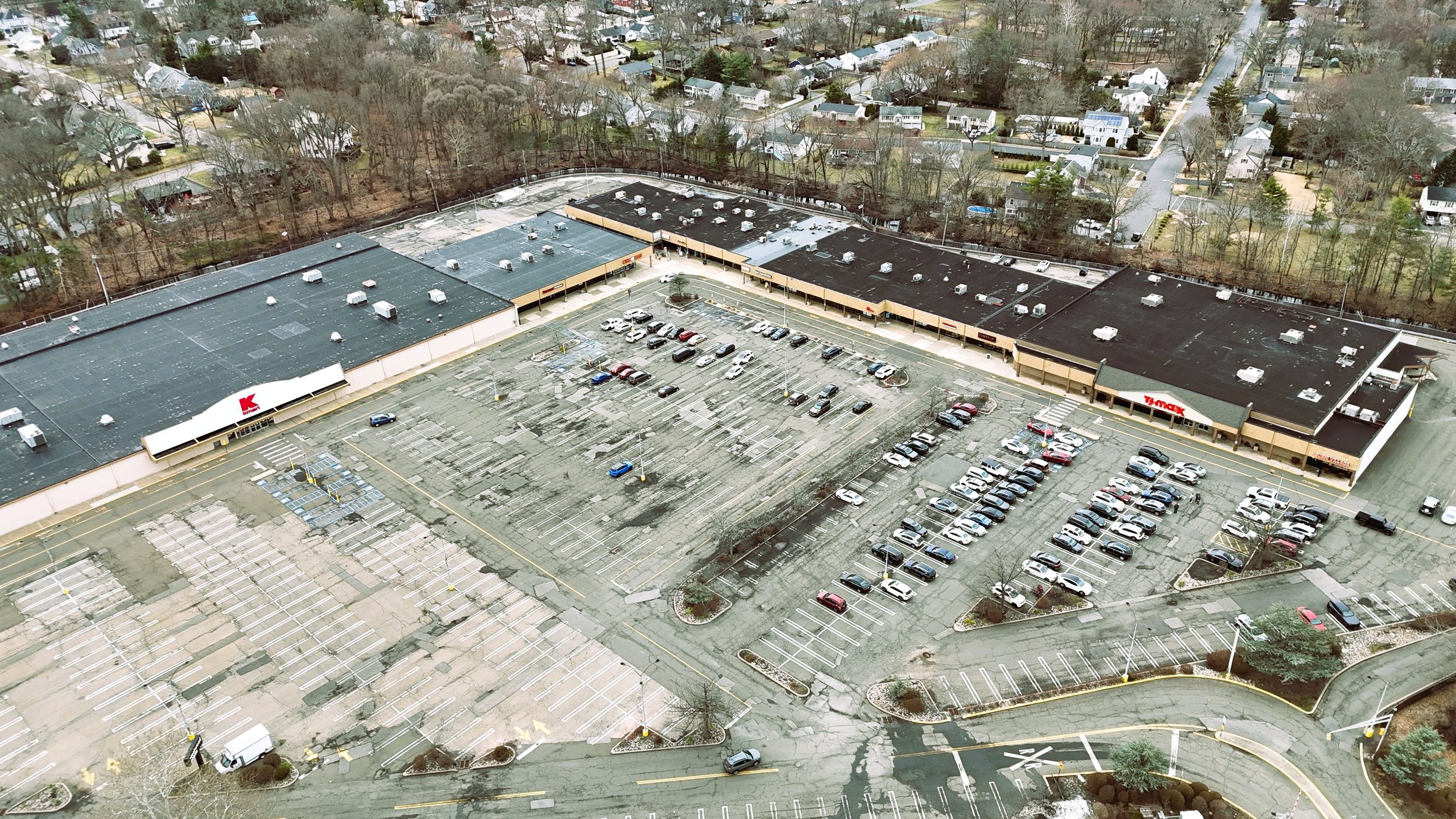 Aerial drone view of Westwood New Jersey shopping plaza showing roof, parking, and surrounding context