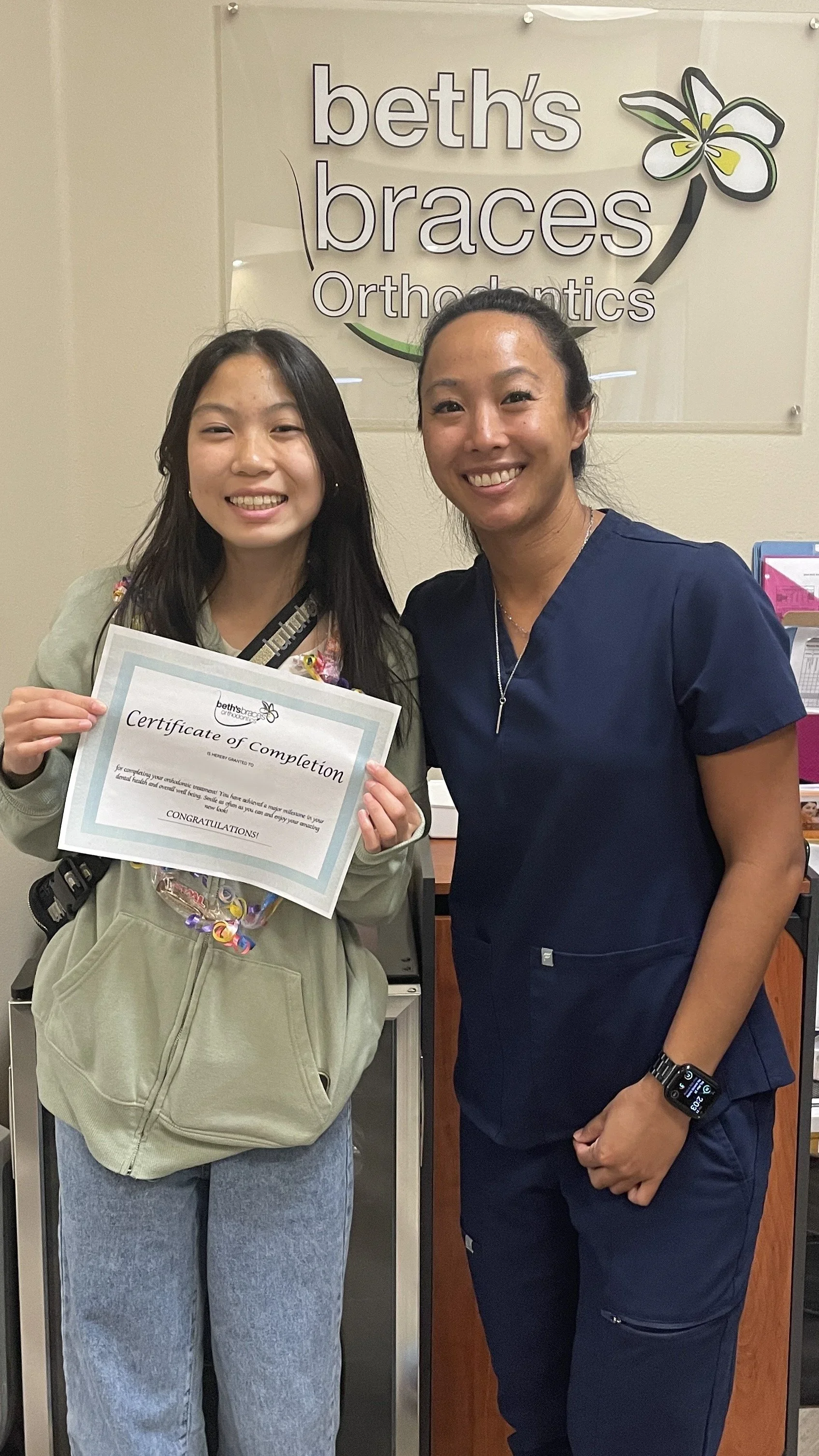 Dr. Beth Yamashiro with a patient holding a treatment completion certificate at Beth's Braces in Las Vegas