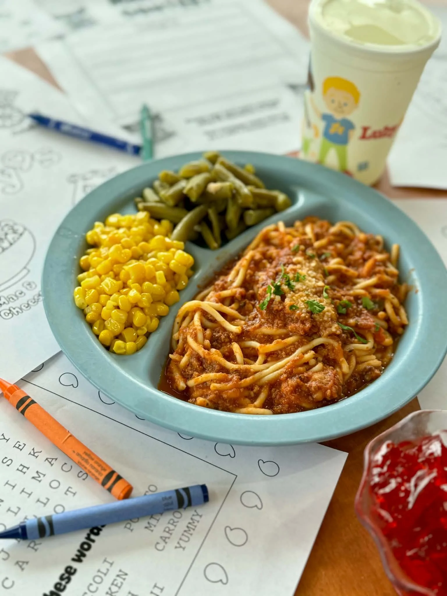 Kids tray with spaghetti, corn, and green beans.