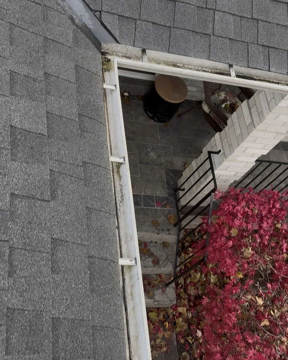 Eavestrough on a roof edge packed with fall leaves