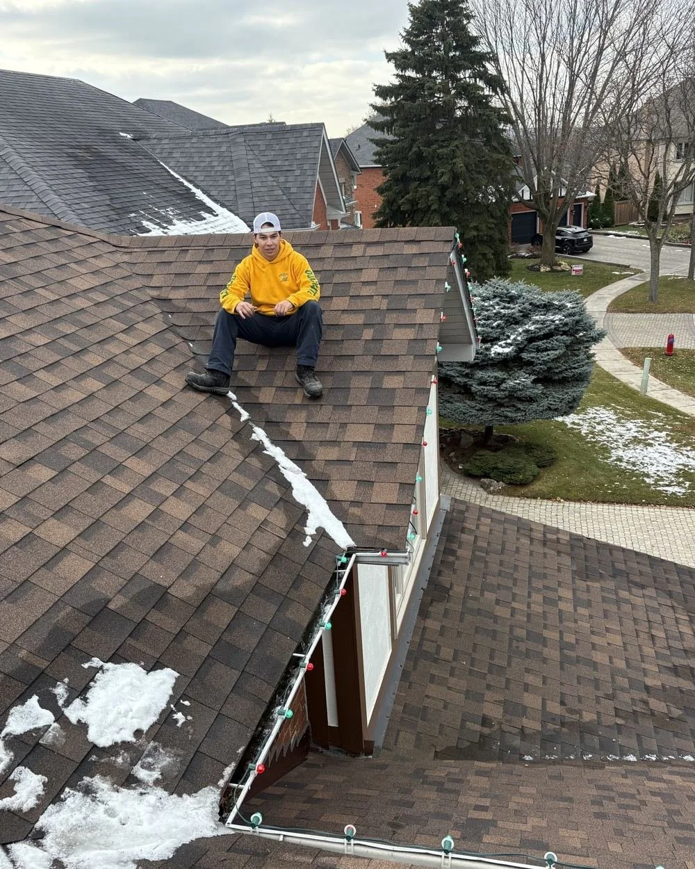 Ryan, owner of QuickCutz, on a roof during a Christmas light install