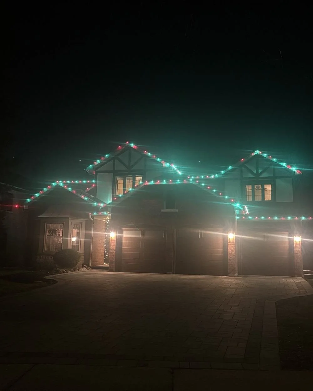 Two-storey home with teal and red roofline lights
