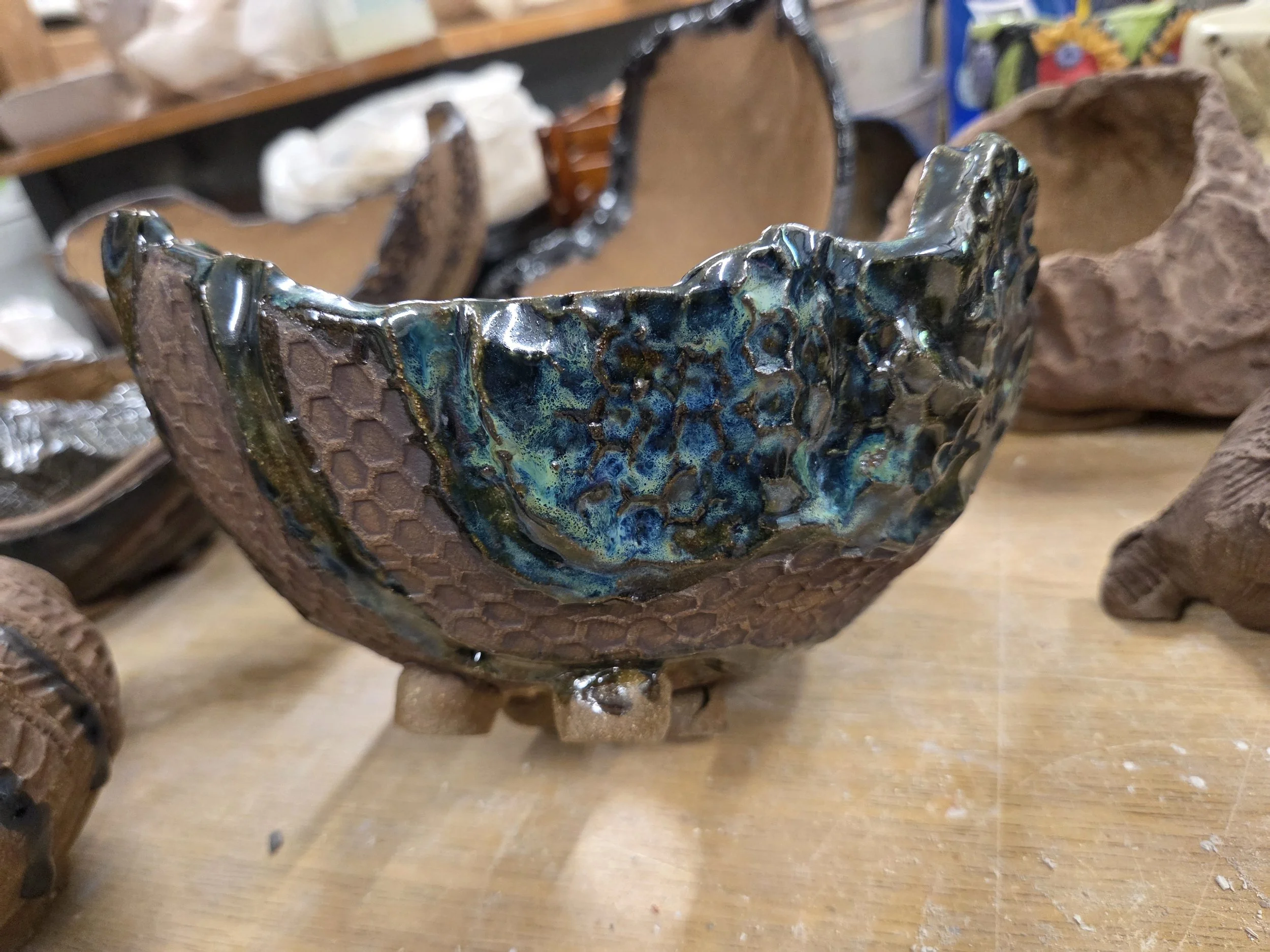 Organic handbuilt vessel by Moe Lewis-Wolf with blue-green glaze and an irregular rim
