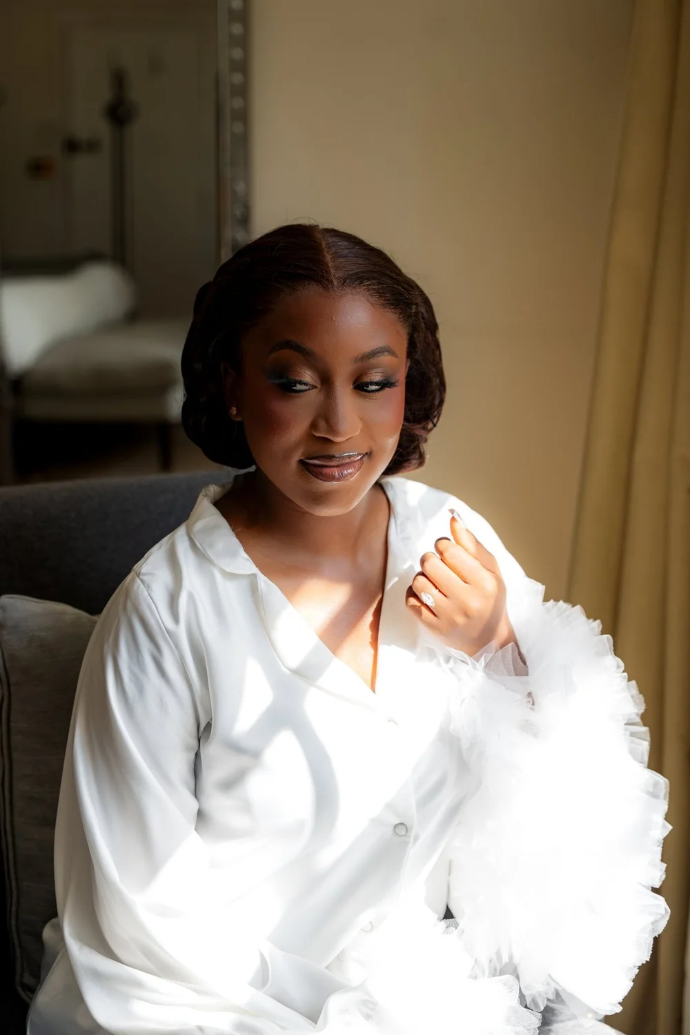Bride in window light during her wedding morning preparations