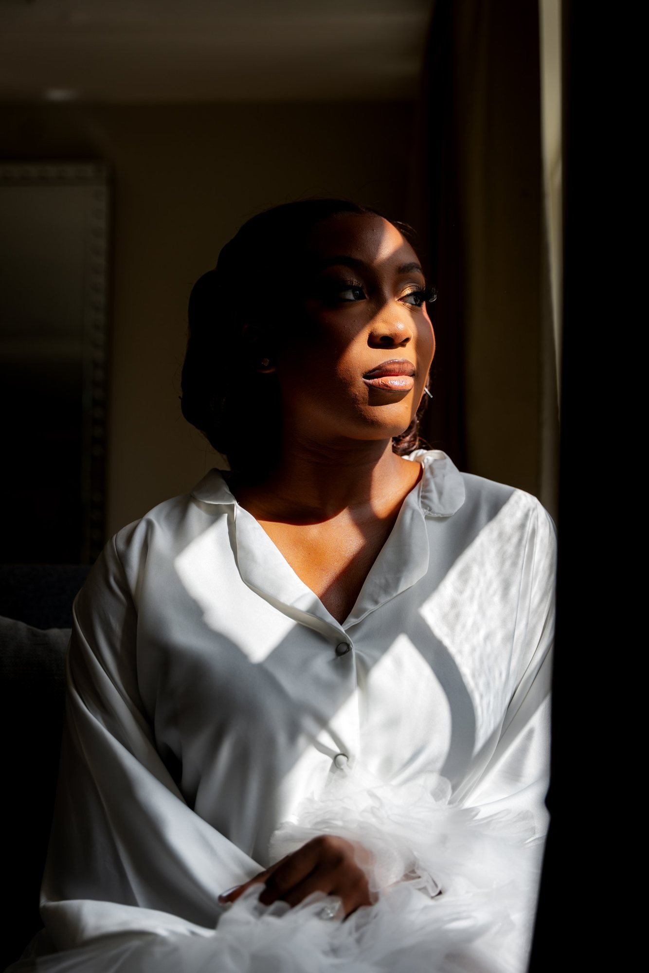 Bride in window light on her wedding morning