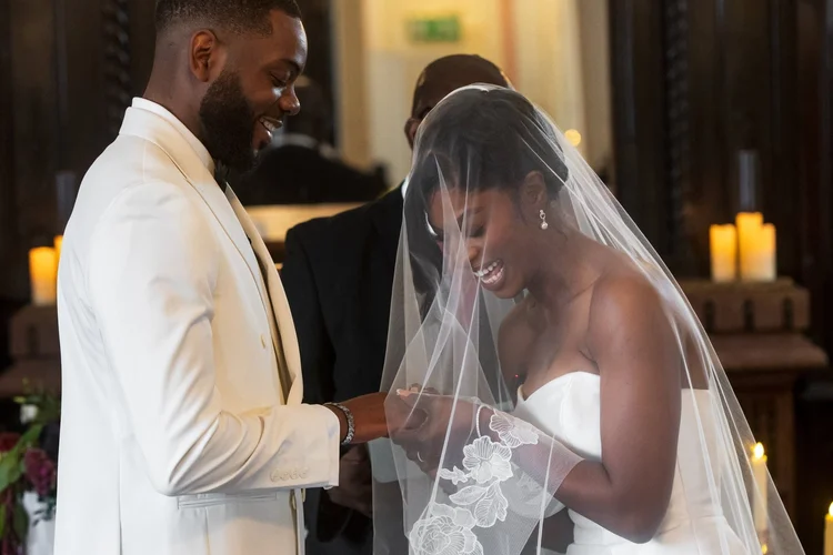 Groom lifting his bride's veil during the wedding ceremony
