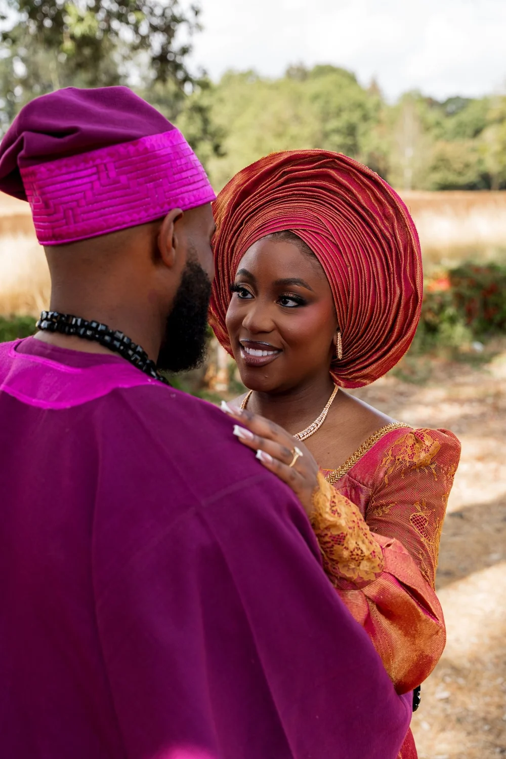 Couple in traditional aso oke attire sharing a moment at their wedding