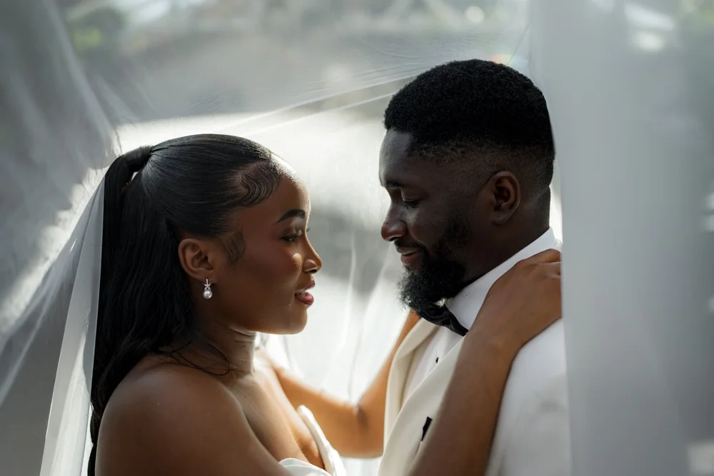Bride and groom sharing a quiet moment behind her veil