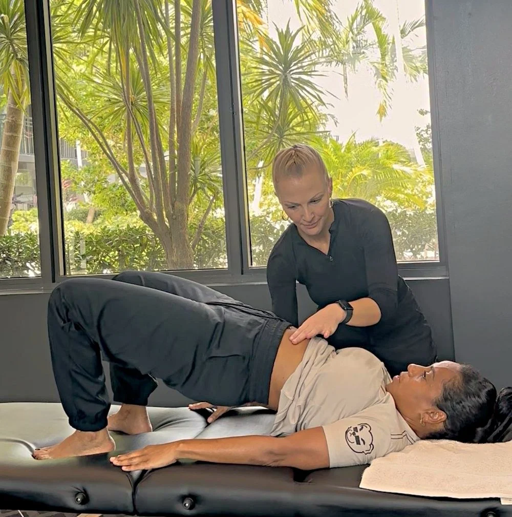 Dr. Karla Kane guiding a client through a Feldenkrais lesson on a treatment table
