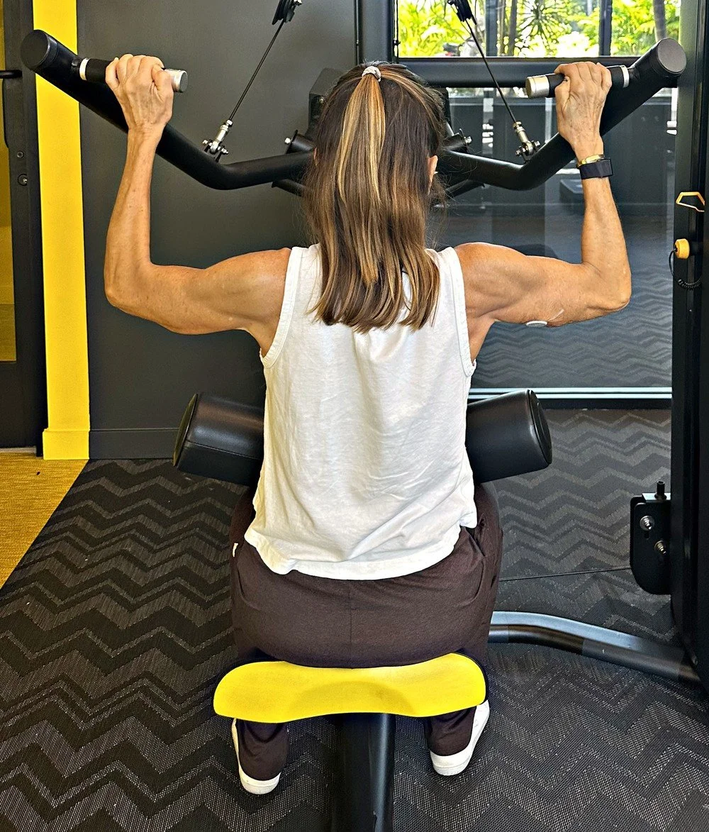 Client training upper-body strength on a cable machine