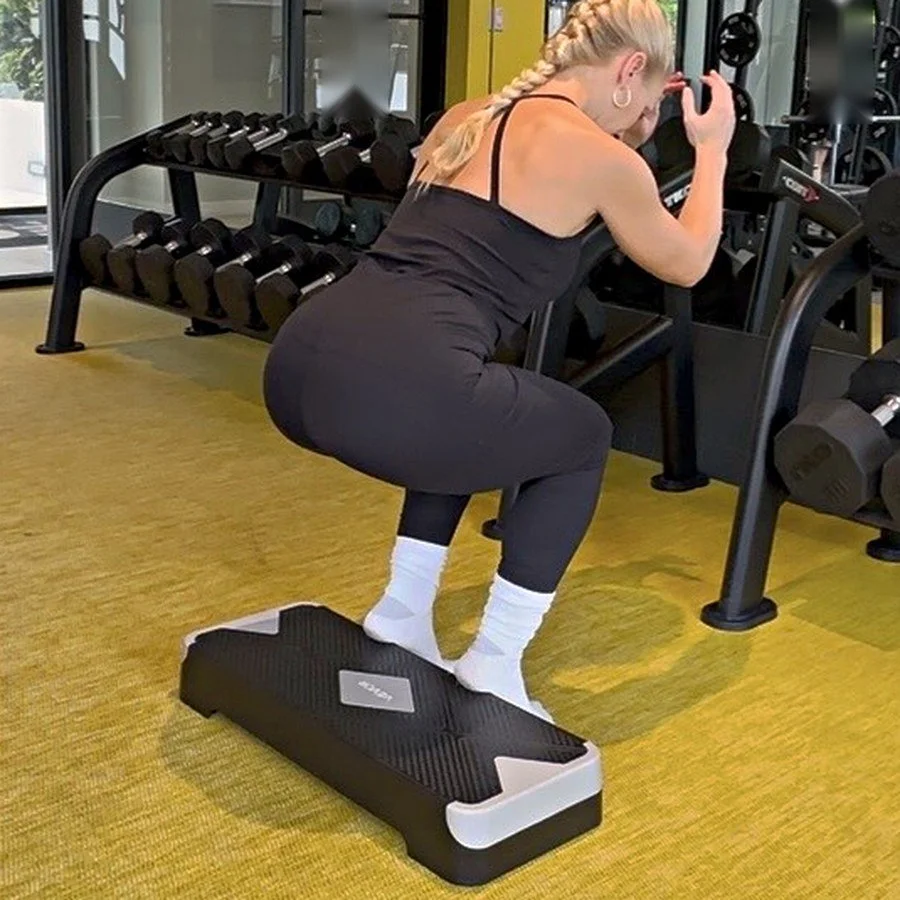 Dr. Karla Kane performing a single-leg step-down squat in the gym