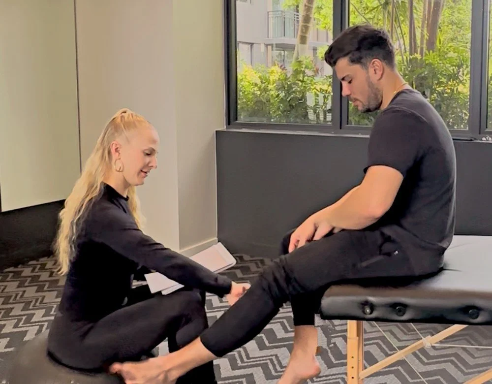 Dr. Karla Kane assessing a seated client’s foot and ankle