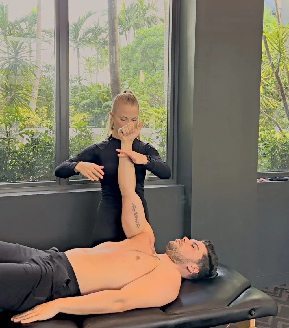 Dr. Karla Kane performing a hands-on shoulder assessment on a patient