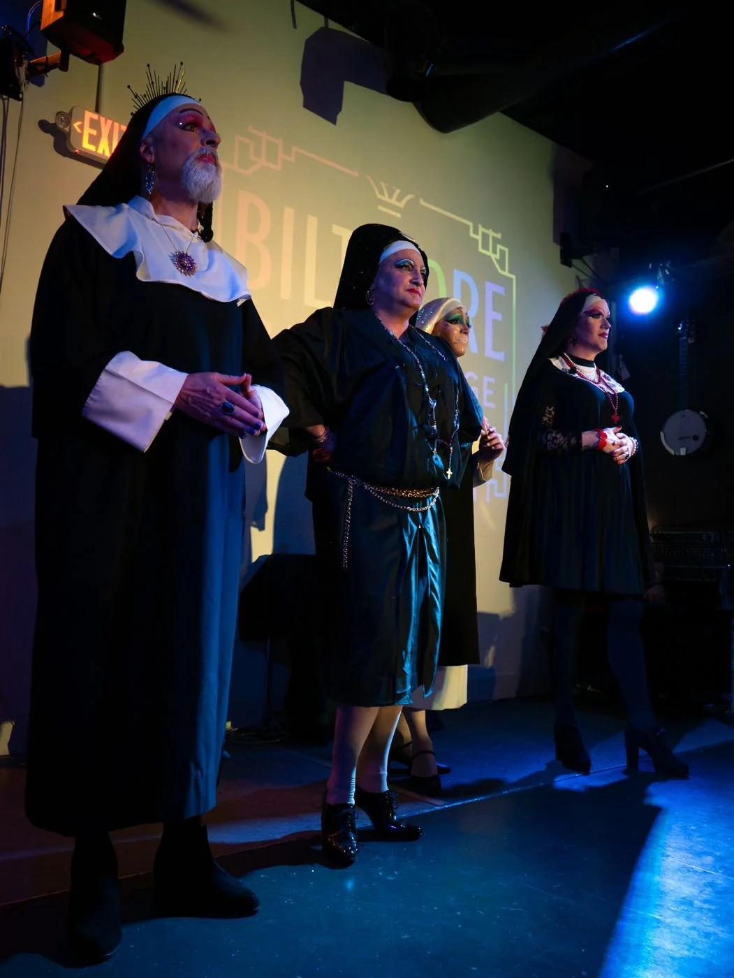 Three Sisters standing in a row on a stage in dark habits and veils.