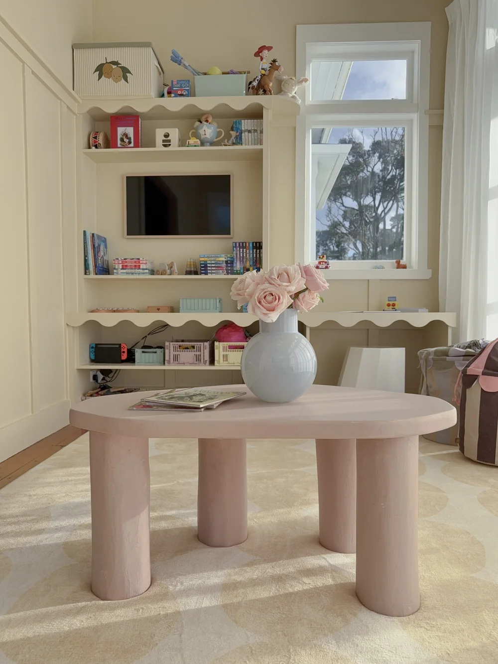 Pink custom microcement coffee table styled with flowers in a light interior