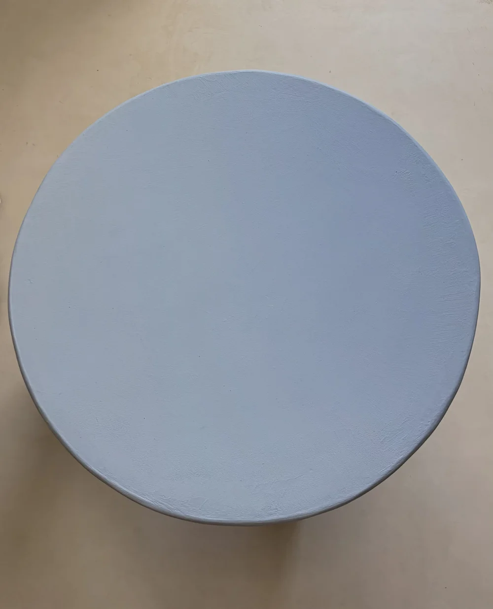 Top view of a blue microcement tabletop showing its hand-applied texture