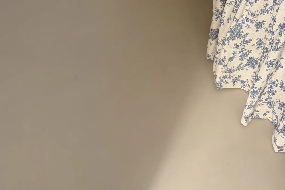 Soft natural light on a microcement wall beside patterned fabric