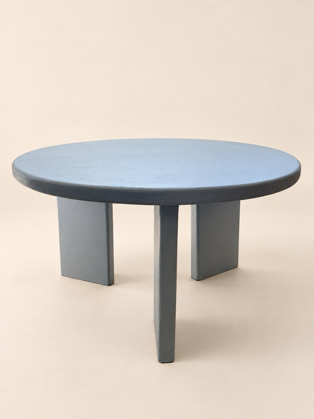 Blue custom microcement table with rounded top and sculptural legs