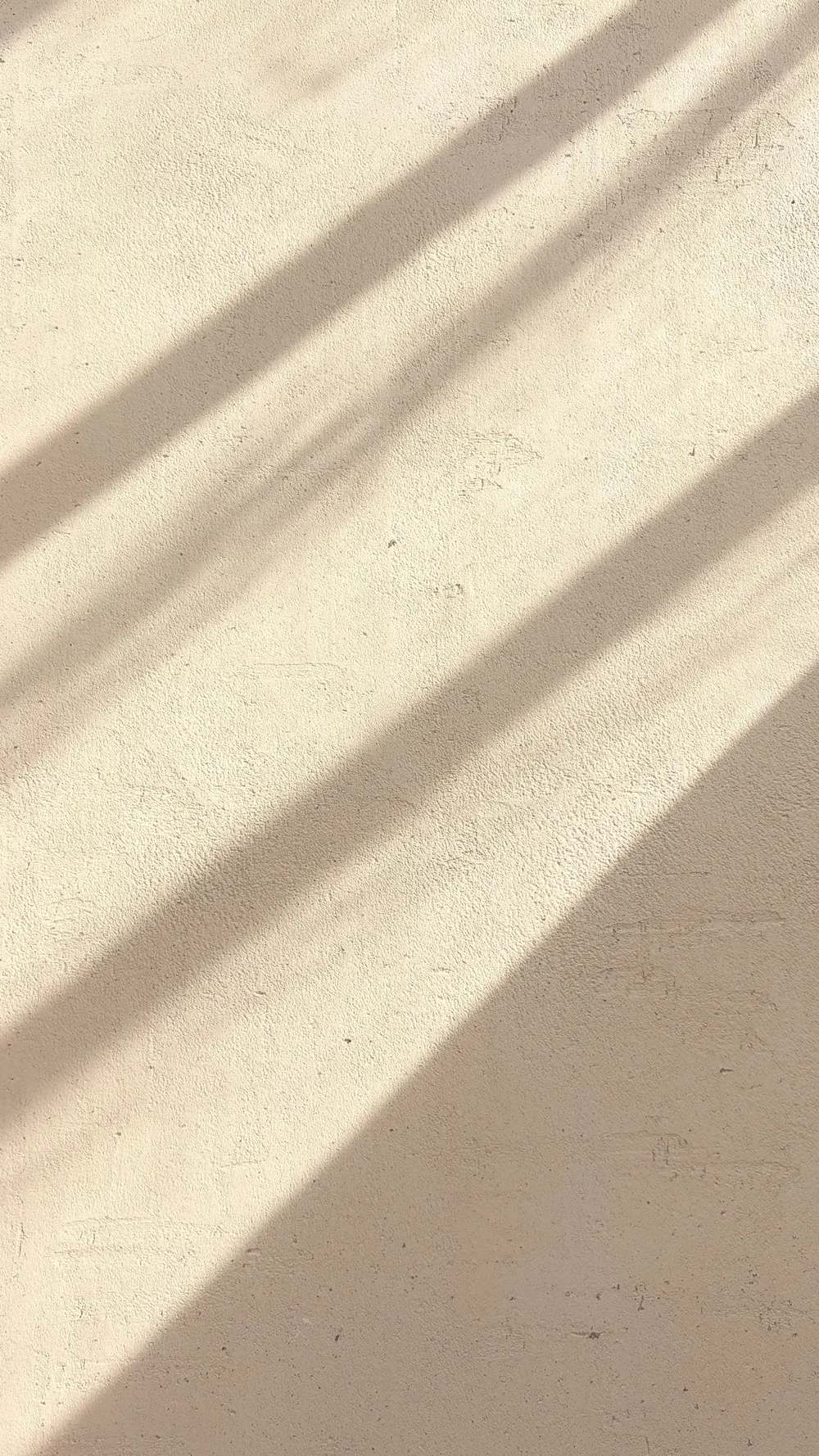 Cream decorative plaster texture with diagonal bands of light and shadow