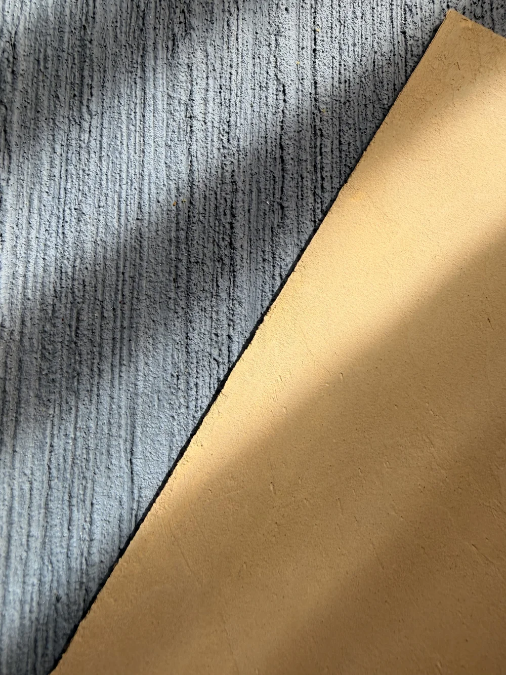 Blue-grey vertically textured finish beside a smooth gold-toned sample