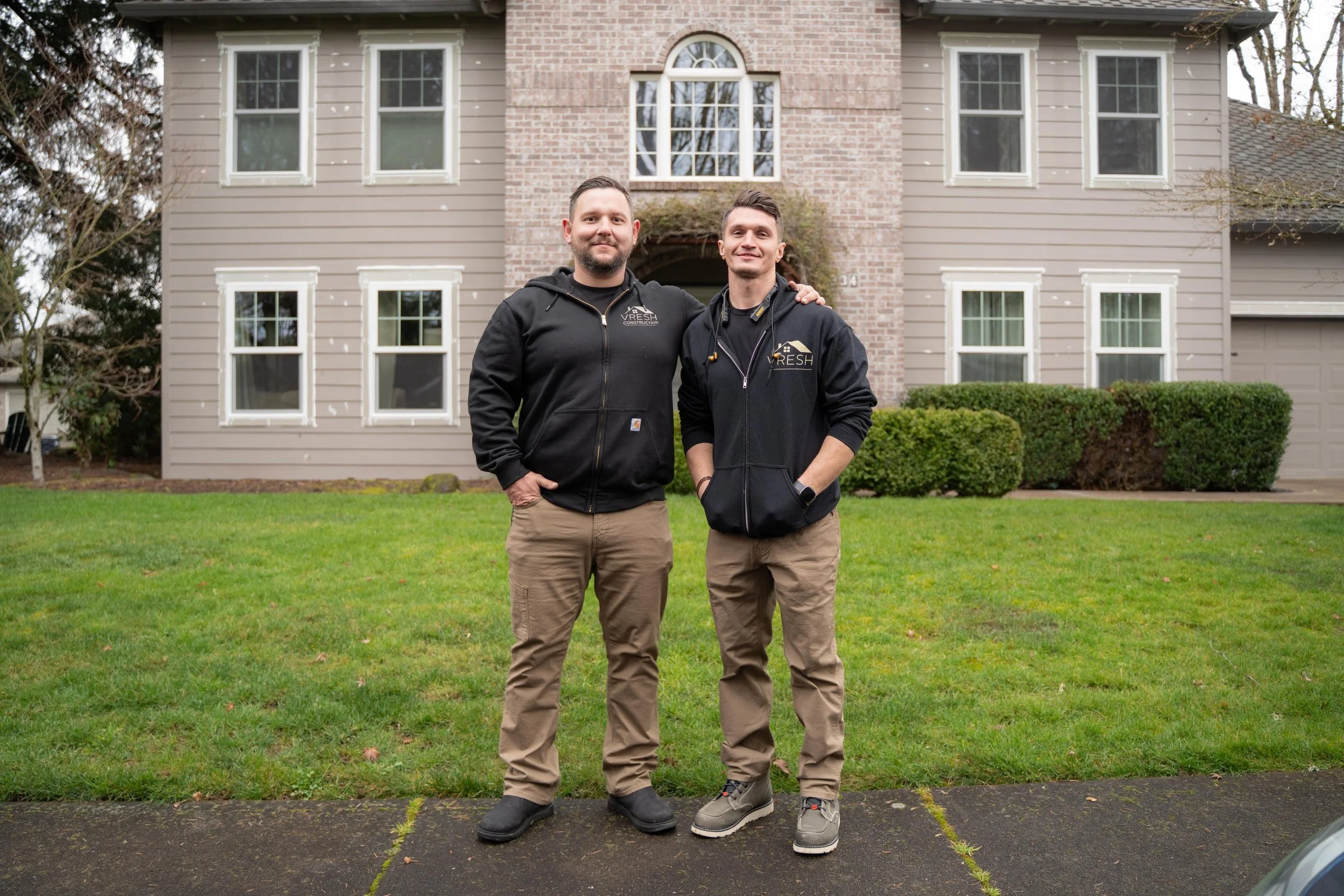 Vlad of VResh Construction and a crew member standing on the lawn of a two-storey Portland home