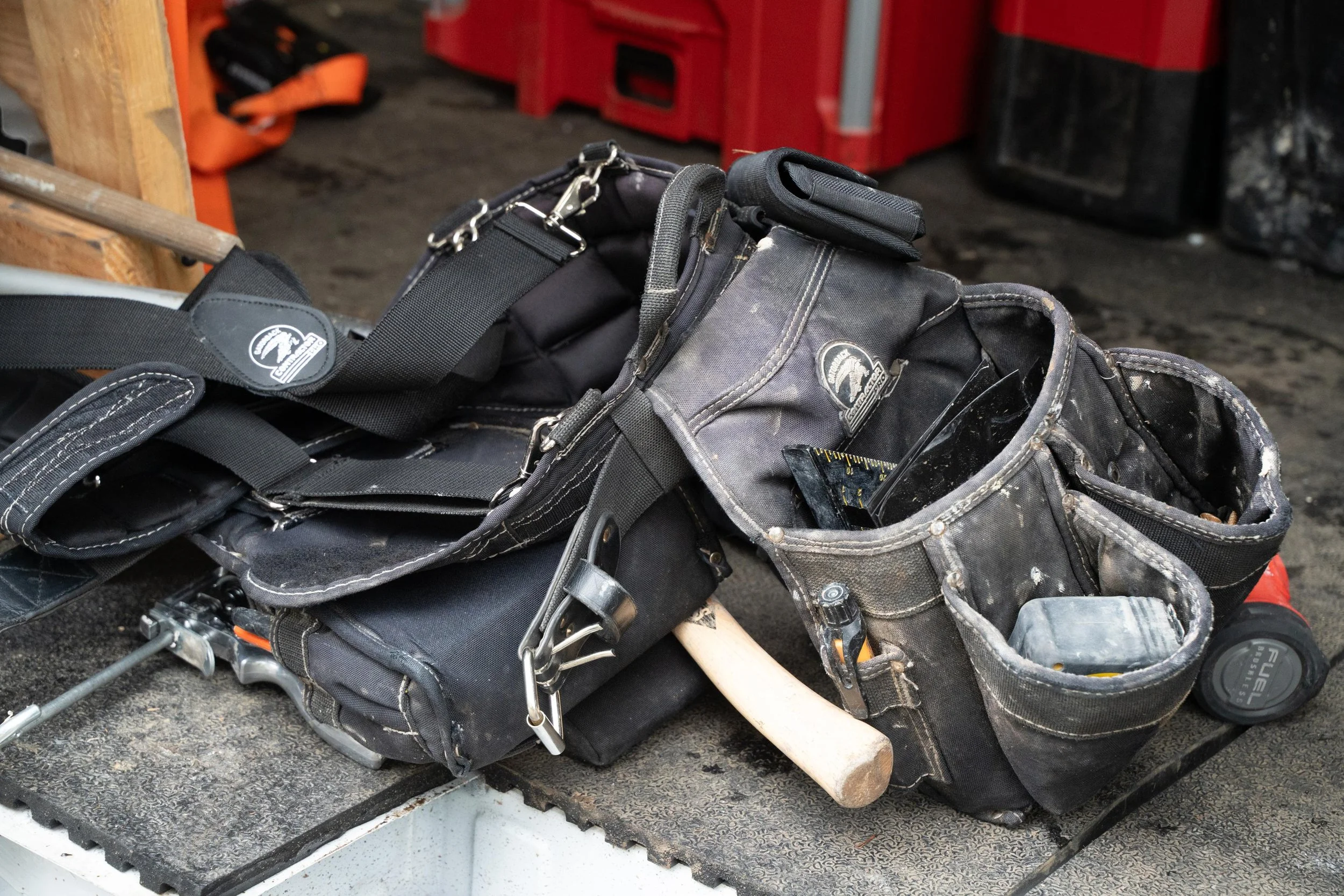 Tool belts and work gear on the floor of the VResh Construction van