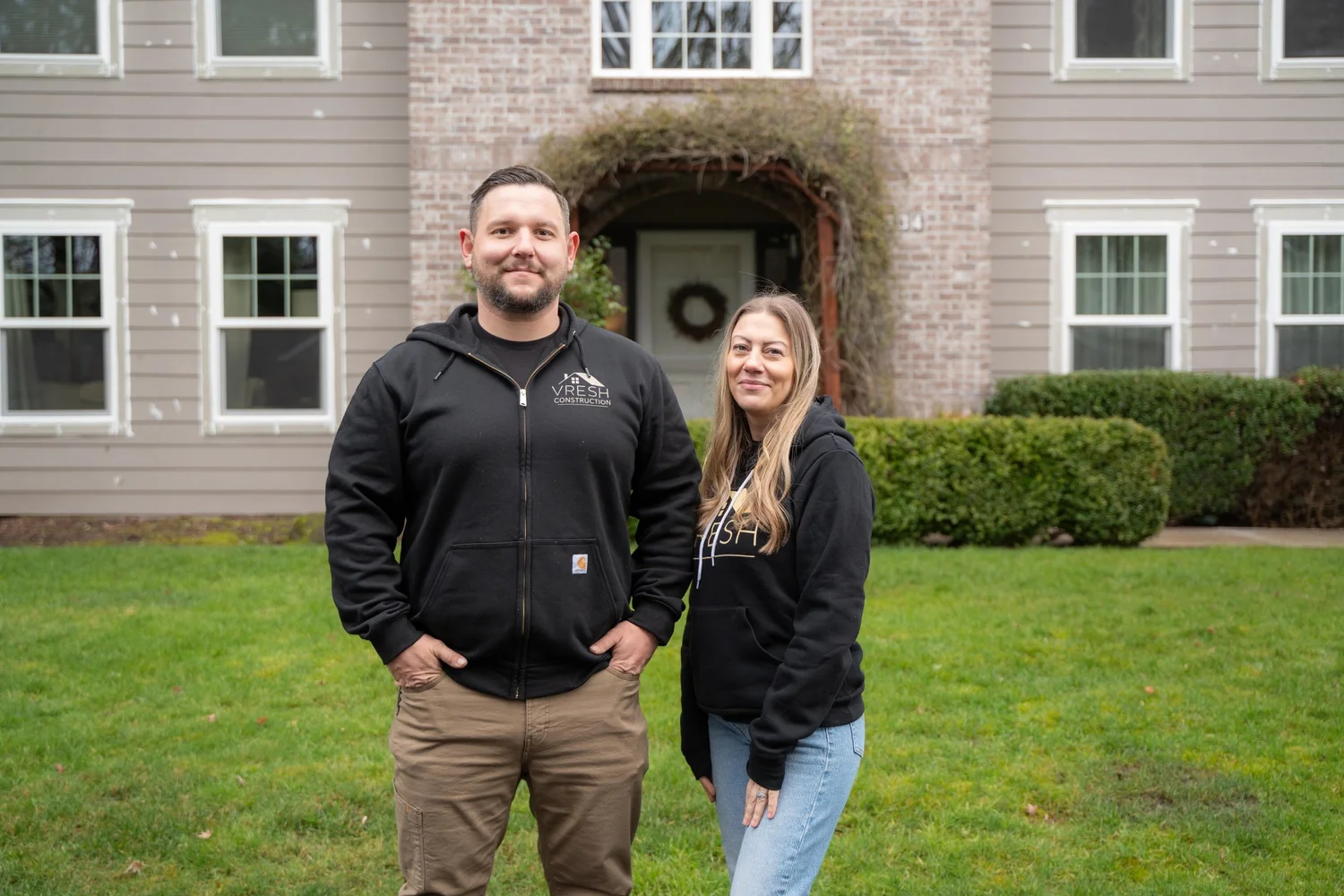 Vlad, owner of VResh Construction, standing with a team member on the lawn of a Portland home