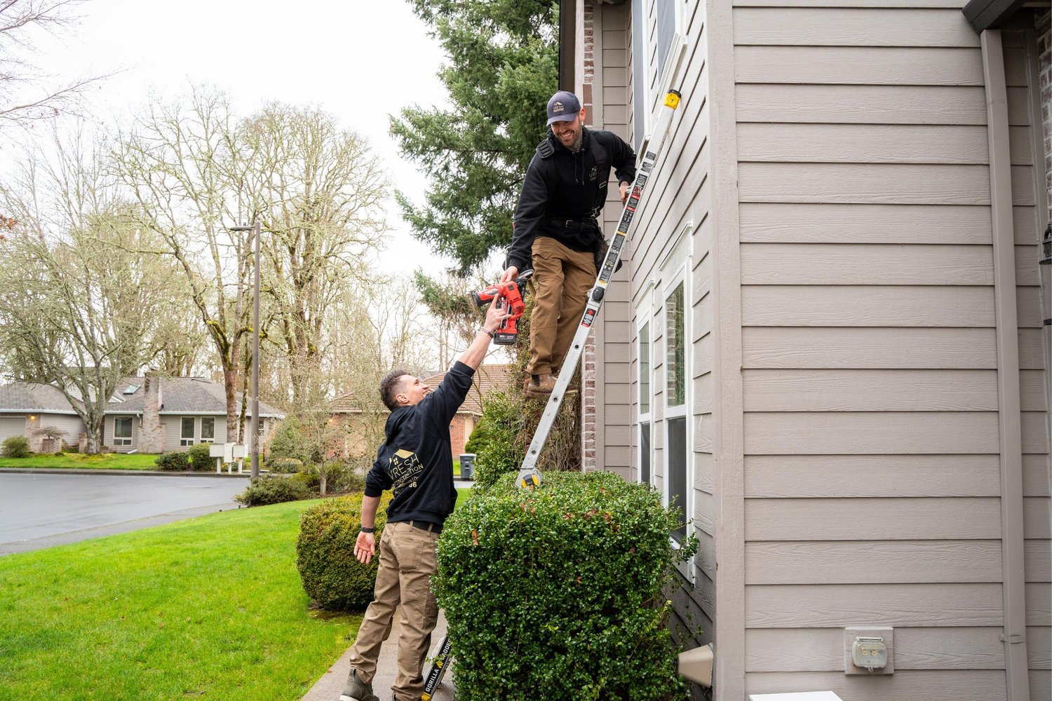 VResh Construction crew passing materials up a ladder to a technician at an upper window of a Portland home
