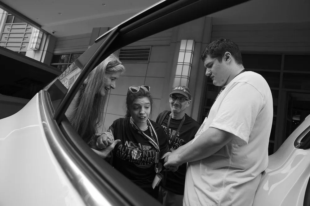 Jadyne rests against the open car door as Luke reassures her.