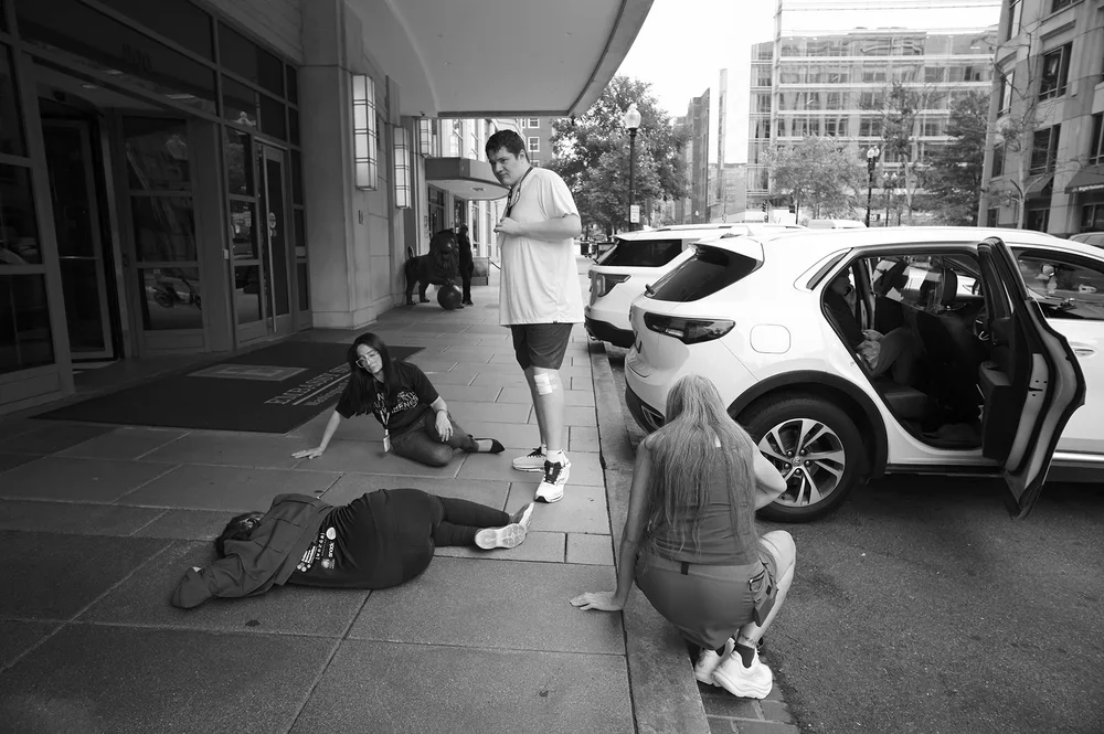 Jadyne lies still on the pavement while other event families keep watch.