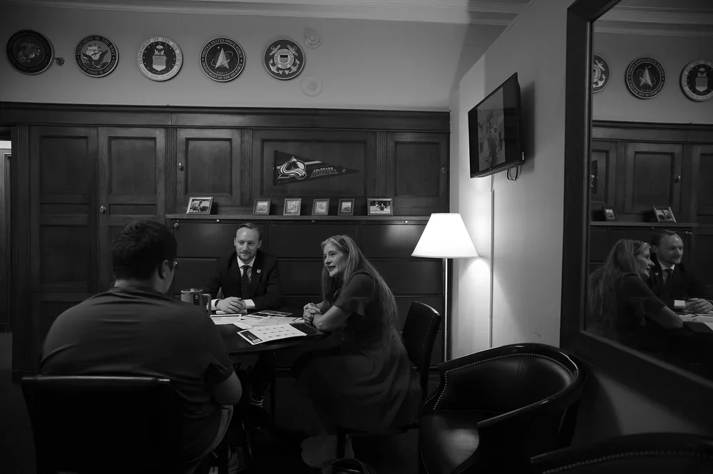 In a Colorado congressional office, a staffer listens as Christine and Luke make their case.