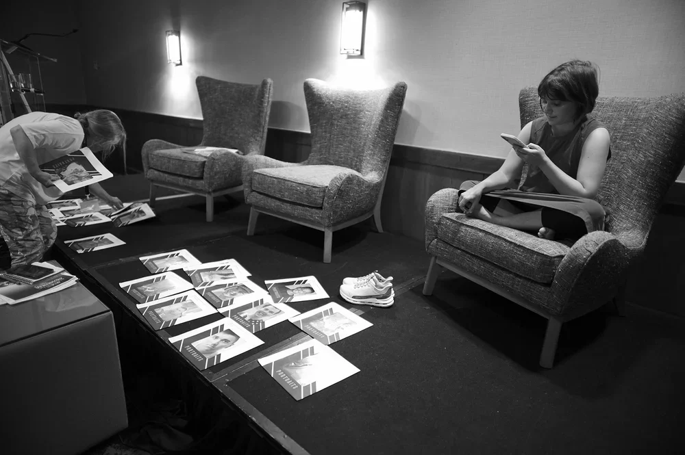 Sophie, a young woman with severe autism, looks out over photographs of children who could not travel.