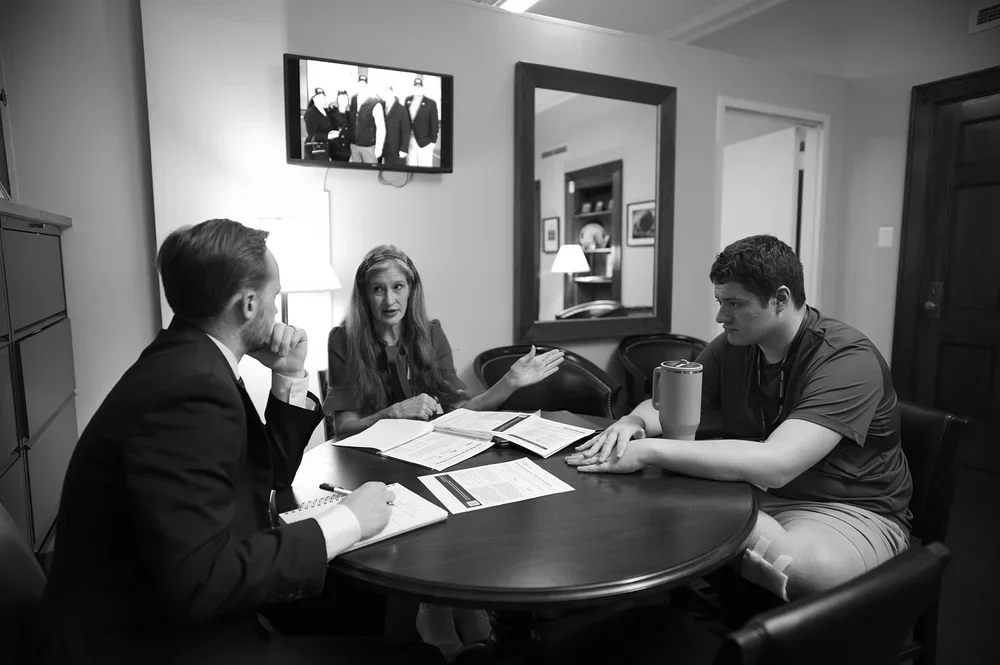 Christine and Luke show a congressional staffer their supporting materials.