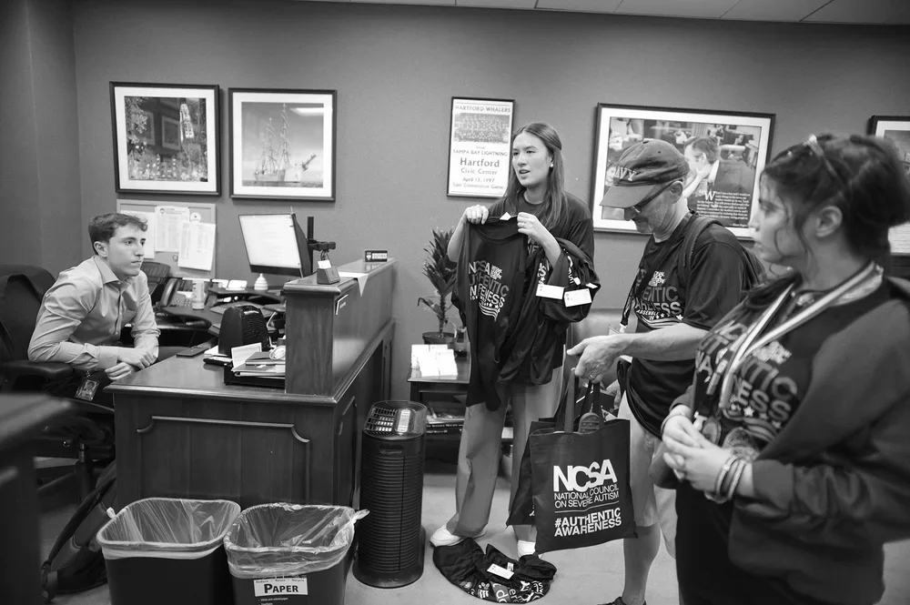 In Senator Chris Murphy's office, Cristina Gaudio holds up an NCSA shirt.