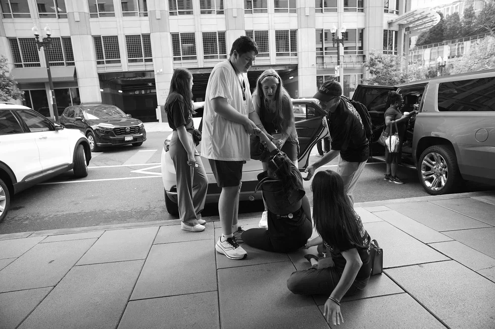 Many hands reach down to help Jadyne up; she takes Luke's.