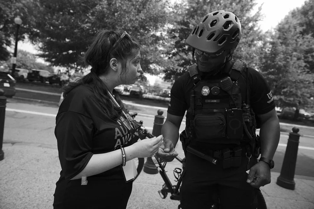 A Capitol Police bike-patrol officer gently takes Jadyne's hand.