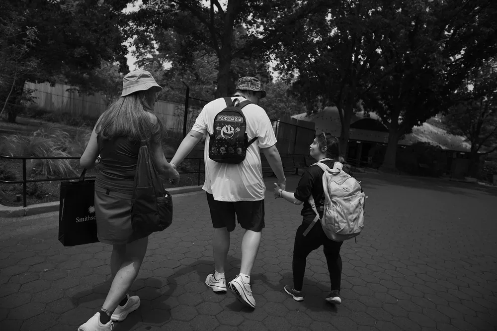 Christine, Luke, and Jadyne walk hand in hand.