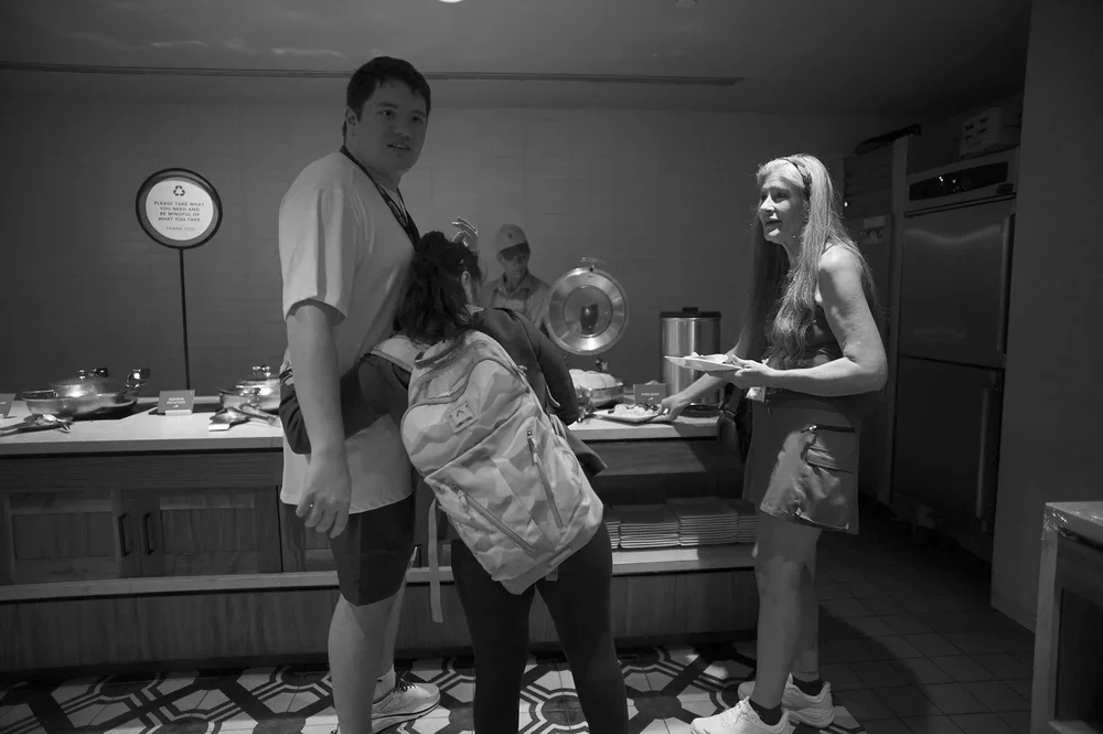 At breakfast, Jadyne embraces Luke as their families fill their plates.