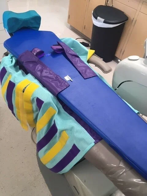  The papoose board features a tight velcro wrap, and fits on a standard dental chair. 